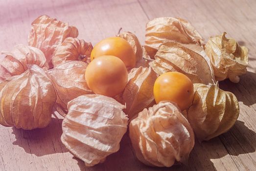 Cape gooseberry (Physalis) on wood table, healthy fruit and vegetable, soft light vintage style