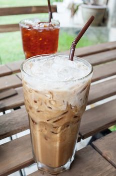 Glass Of Cold Coffee With Milk On Wooden Table for Summertime, selective focus