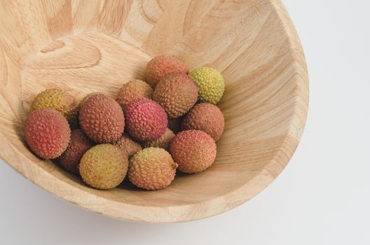 lychee fruit in a wooden bowl, white background
