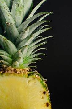 sliced pineapple fruit closeup on black background