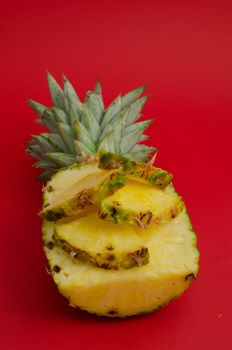 sliced pineapple fruit on red background, triangles