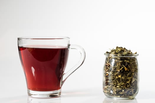 Tea in a glass on a white background. Green or fruit tea. Glass of white glass