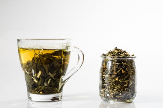 Tea in a glass on a white background. Green or fruit tea. Glass of white glass