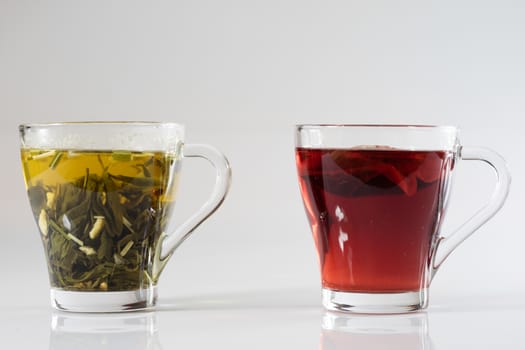 Tea in a glass on a white background. Green or fruit tea. Glass of white glass