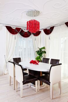 White glossy table with leather chairs in white classical interior