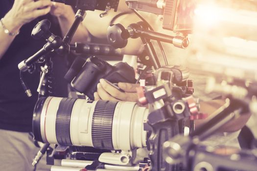 Cameraman with his video camera shooting, Hands Adjusting Camera,film production crew, behind the scenes background.