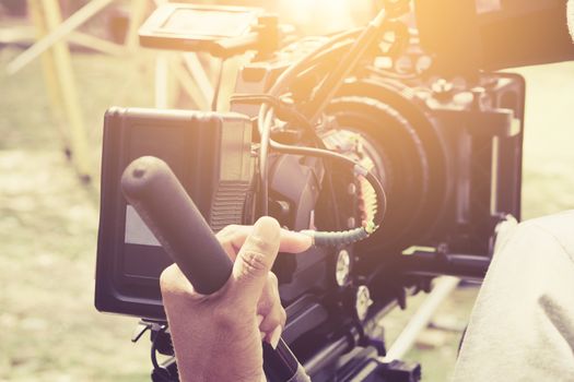 Cameraman with his video camera shooting, Hands Adjusting Camera,film production crew, behind the scenes background.