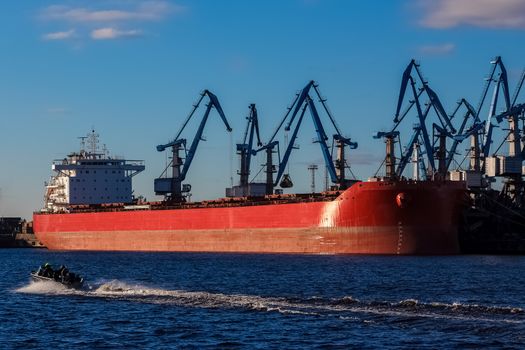 Red cargo ship loading in the port of Riga, Europe
