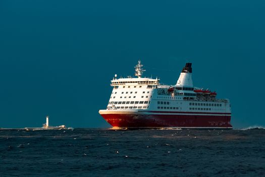 Red cruise liner. Passenger ship sailing from the sea in the morning