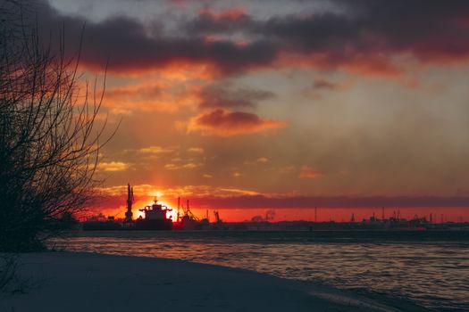 Colorful winter sunrise against the cargo port