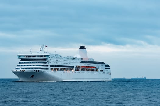 White cruise liner. Passenger ferry moving in still water