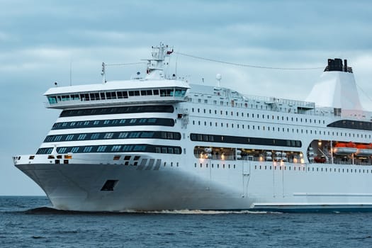 White cruise liner. Passenger ferry moving in still water