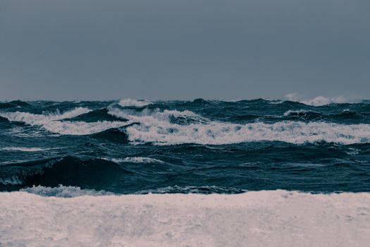 Big waves at the sea in stormy weather. Toned dark blue