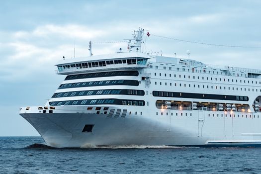 White cruise liner. Passenger ferry moving in still water