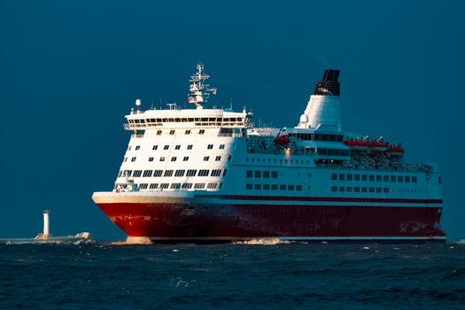 Red cruise liner. Passenger ship sailing from the sea in the morning