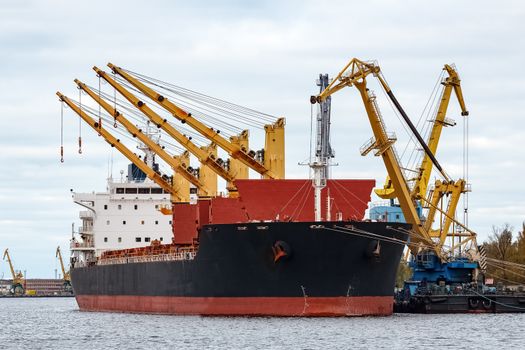 Black cargo ship loading in the port of Riga, Europe