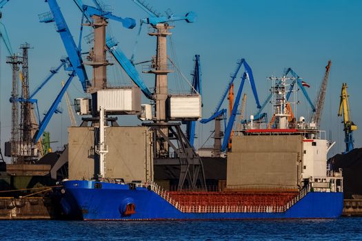 Blue cargo ship loading in the port of Riga, Europe