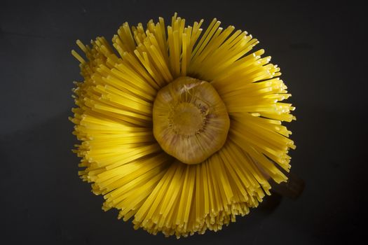 Macaroni and garlic on a black stone board