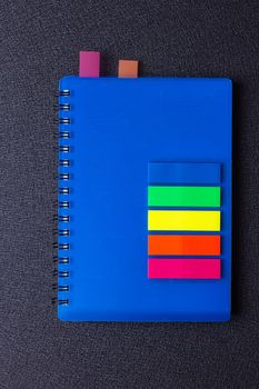 Blue notepad on a spiral with a sticker on a black background