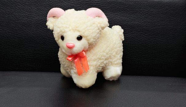 Soft baby toy white sheep isolated on black background.