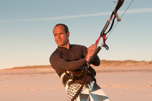 Kite surfer watching the waves at sunset in Portugal.