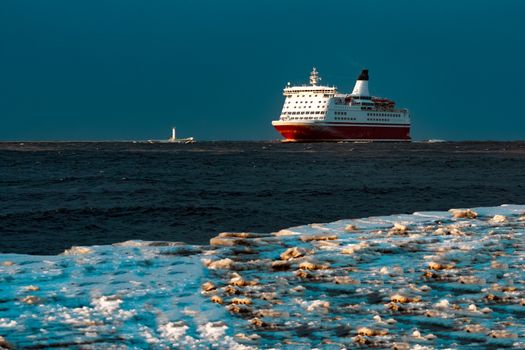 Red cruise liner. Passenger ship sailing from the sea in the morning
