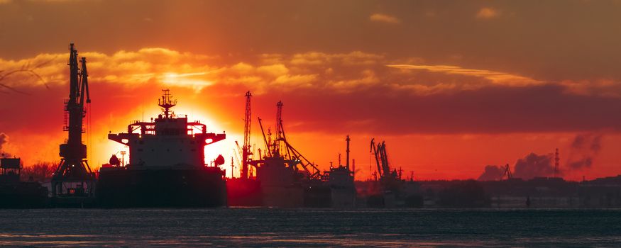 Colorful winter sunrise against the cargo port