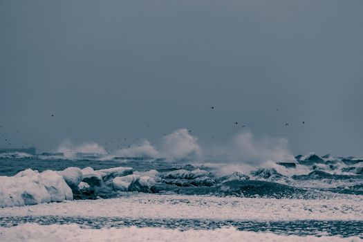 Big waves at the sea in stormy weather. Toned dark blue