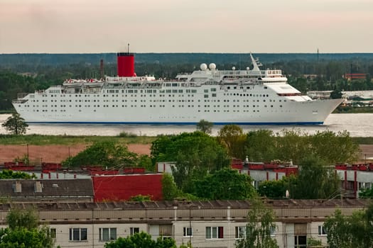 White passenger ship. Cruize ferry sailing past old town