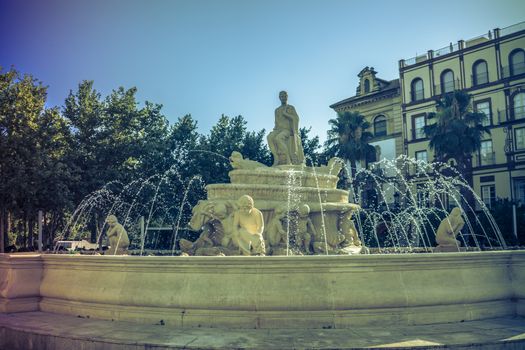 Water fountain with a statue in a main square in Seville, Spain, Europe