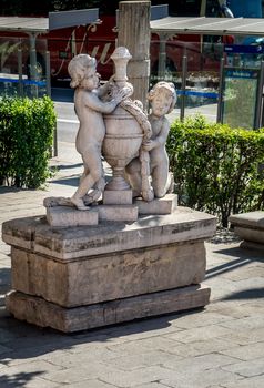 White marble sculpture of 2 children holding a water pot in Madrid, Spain, Europe