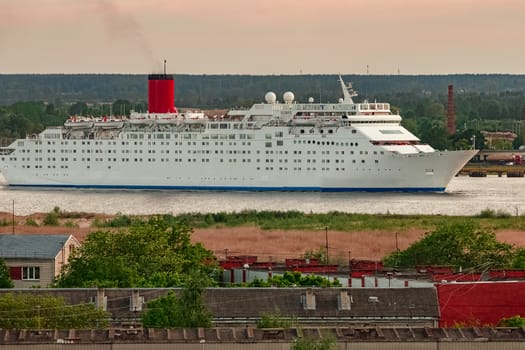 White passenger ship. Cruize ferry sailing past old town