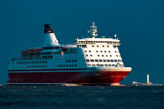 Red cruise liner. Passenger ship sailing from the sea in the morning