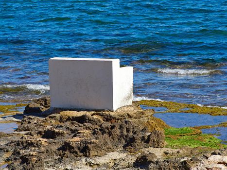 Bench made of stone in beautiful popular summer tourism destination Torrevieja beach, Costa Blanca, Valencia, Spain