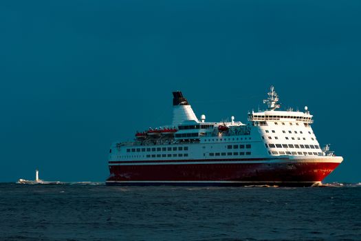 Red cruise liner. Passenger ship sailing from the sea in the morning