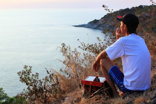 Lonely man looking with hope at horizon with sunlight during sunset  