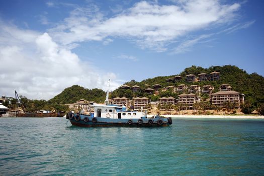An old fishing boat on the background of the island of Boracay