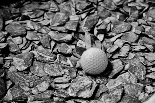 Small white dirty gold ball staying on grey stones. Closeup photography.