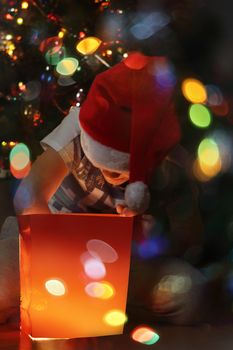 Happy little boy opens his magic glowing christmas gift near decorated christmas tree