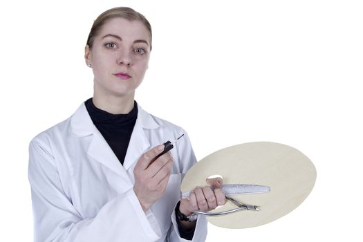 Young woman in a white coat with a manicure tool and a palette