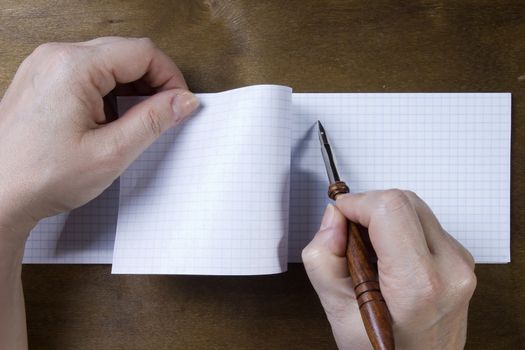 Hand writing in a note book on a wooden background