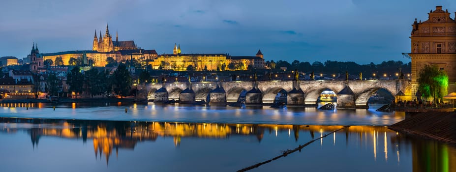Prague, Czech Republic - May 25, 2016: Night view over river Vltava to Charles bridge and Prague castle with copy space in clear sky