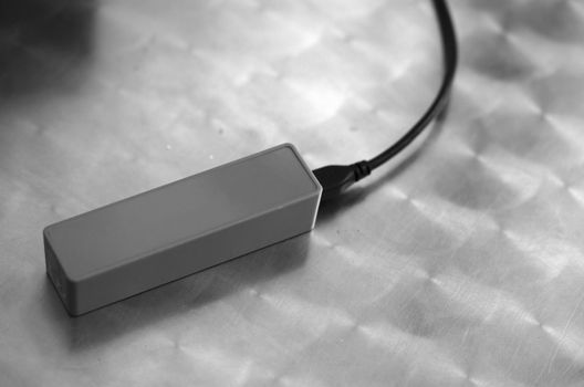 BLACK AND WHITE PHOTO OF CHARGING PORTABLE BATTERY POWER BANK CHARGER