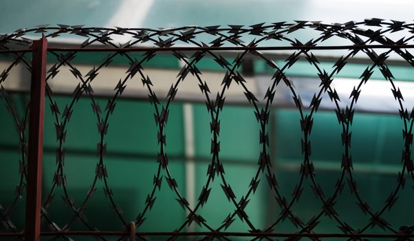 COLOR PHOTO OF SILHOUETTE METAL RAZOR WIRE FENCING