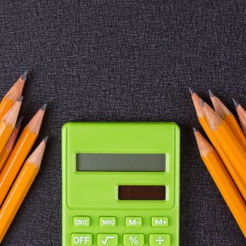 pencil and calculator on the black background