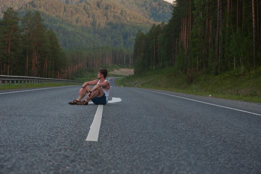 Man sitting on the beauty road in mountain