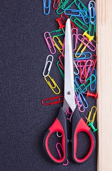 Scissors and paper clips on a black background