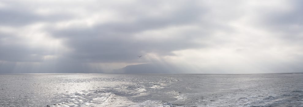 Panorama of Godrays and morning view of ocean from boat at Pelican Bay on Santa Cruz Island, Channel Islands.