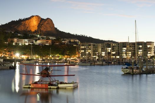 Biplane with boats in marina at dusk, Townsville, Queensland, Australia