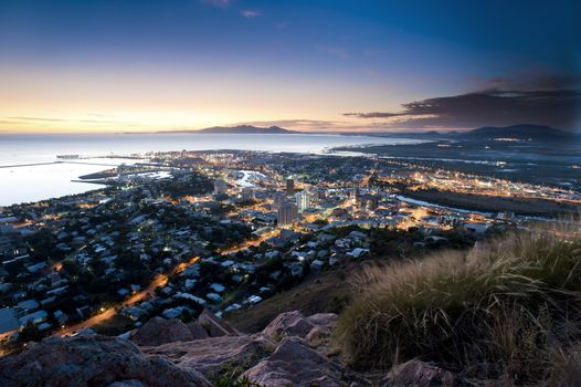 Cityscape of illuminated Townsville and ocean at dusk, Australia